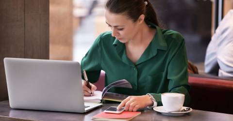 Zzp'er vrouw aan het werk achter haar laptop in een café